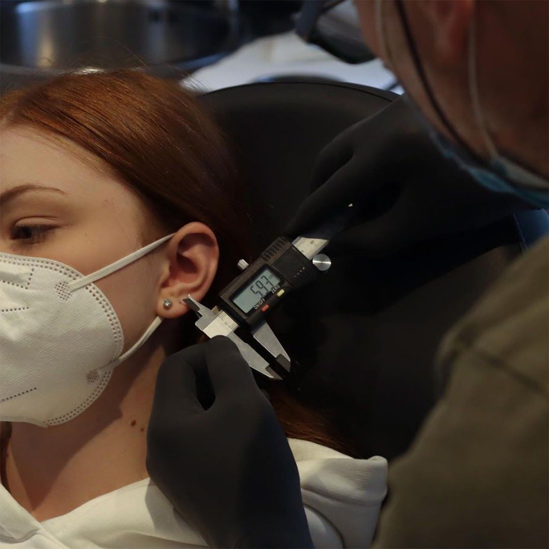 a woman getting her teeth examined by a dentist