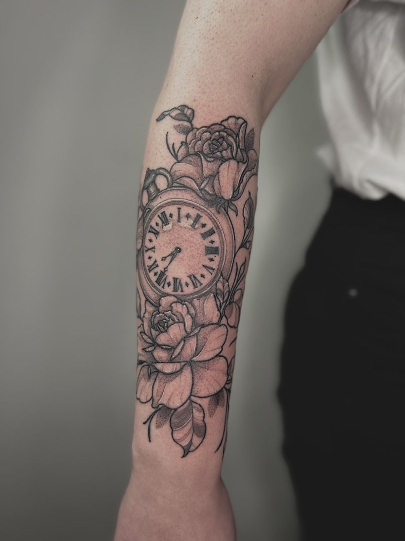 a clock with roses on the arm