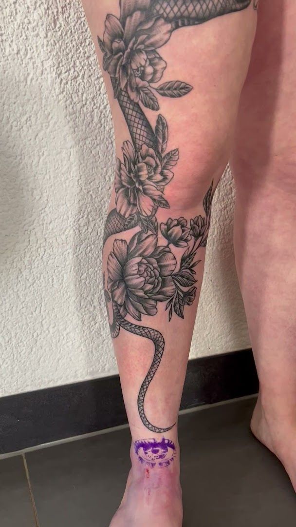 a woman's leg with a snake cover-up tattoo on it, kaiserslautern, germany