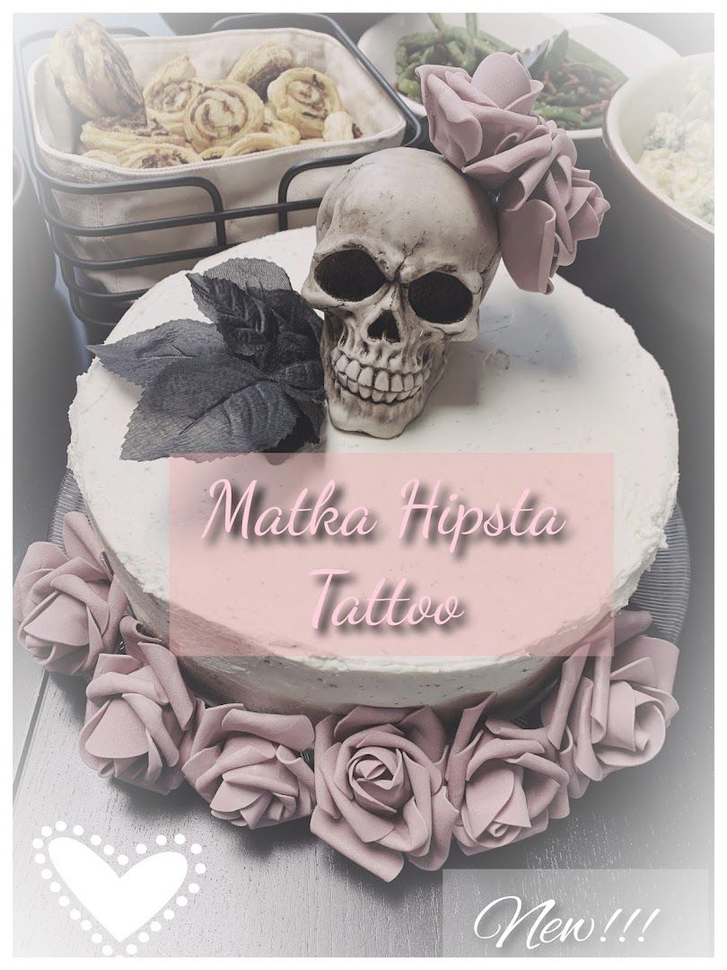 a cake with a skull on top and a pink rose on the bottom