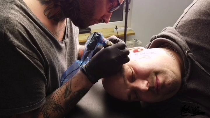 a man getting his narben tattoo done by a tattoo artist, rendsburg-eckernförde, germany