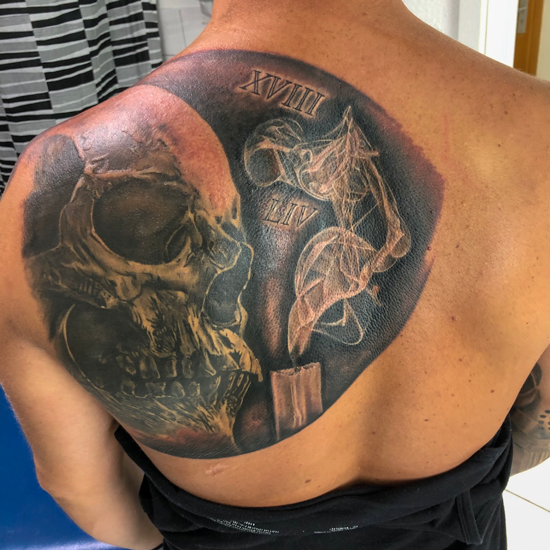 a man with a skull cover-up tattoo on his back, kleve, germany