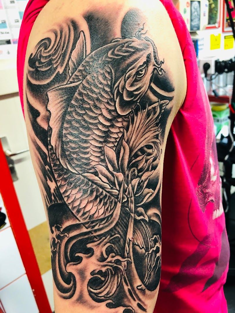 a black and grey cover-up tattoo of a fish on the arm, schwerin, germany