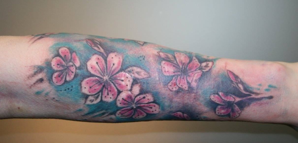 a narben tattoo with pink flowers on the arm, bodenseekreis, germany