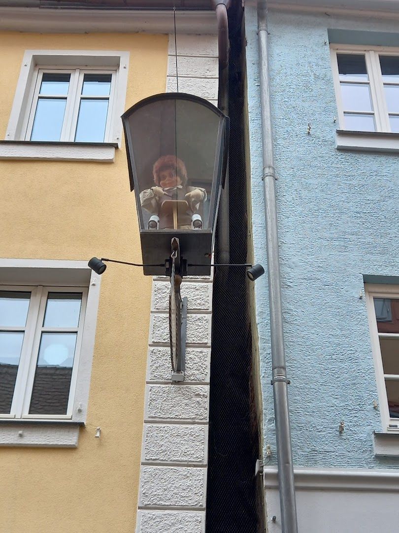 a cat is hanging from a window in a building