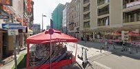 a street with a red umbrella and a red chair