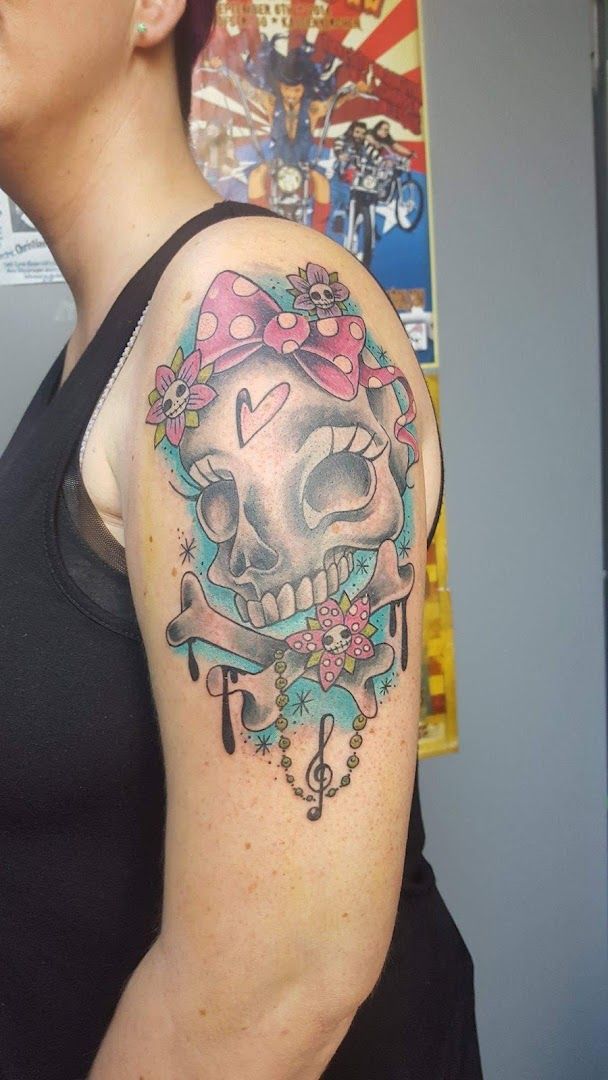 a woman with a skull and flowers on her shoulder