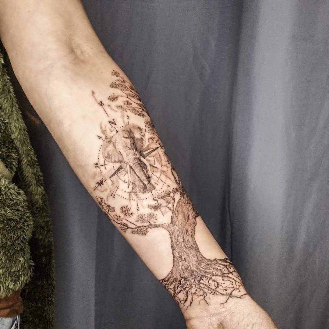 a man's arm with a cover-up tattoo of a tree and a bird, paderborn, germany