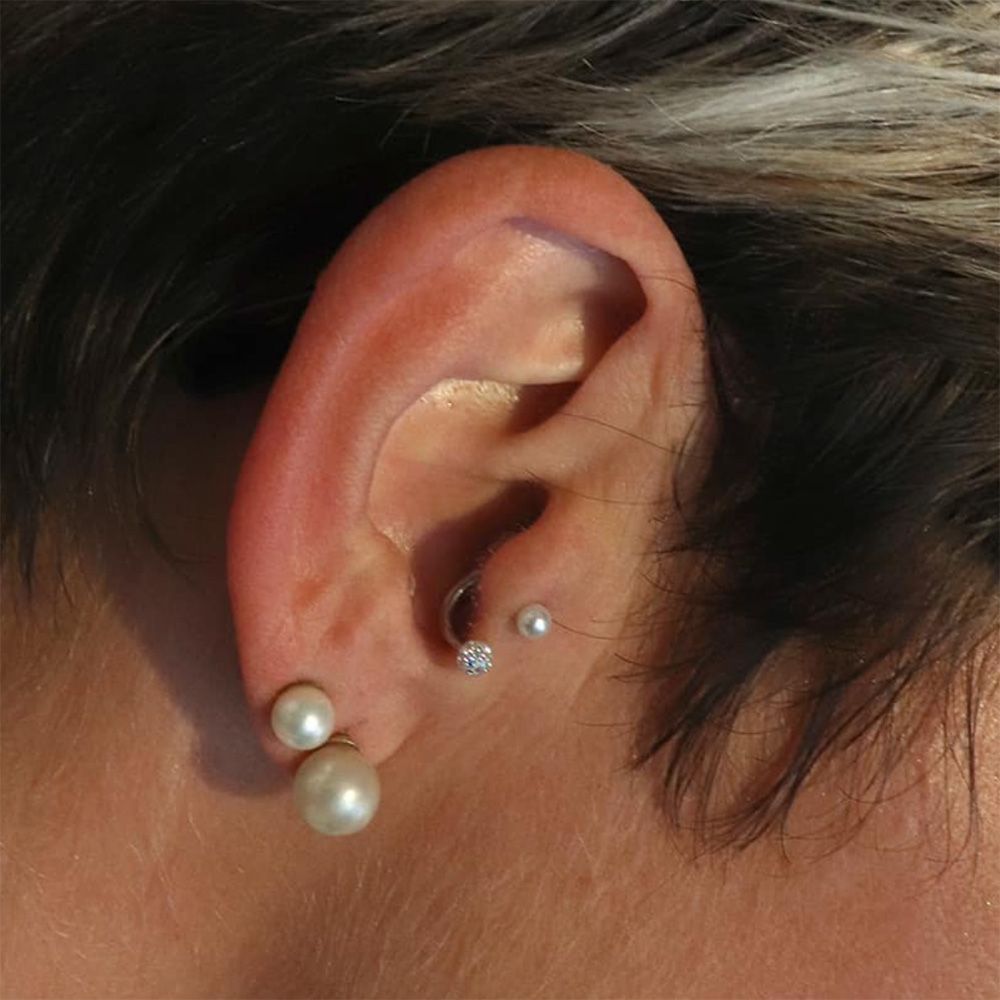 a woman wearing a pearl ear piercing