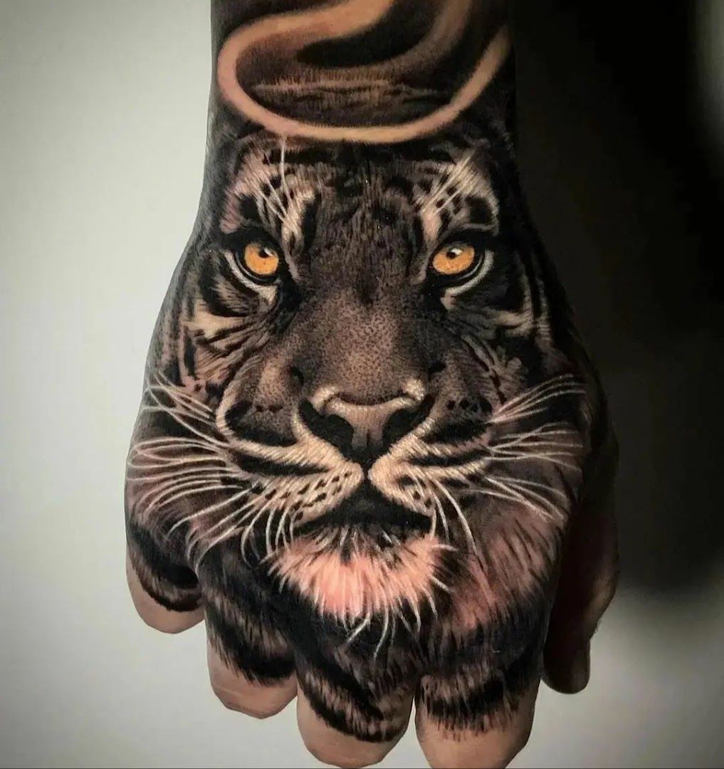 a hand cover-up tattoo of a tiger with a hat on it, dachau, germany