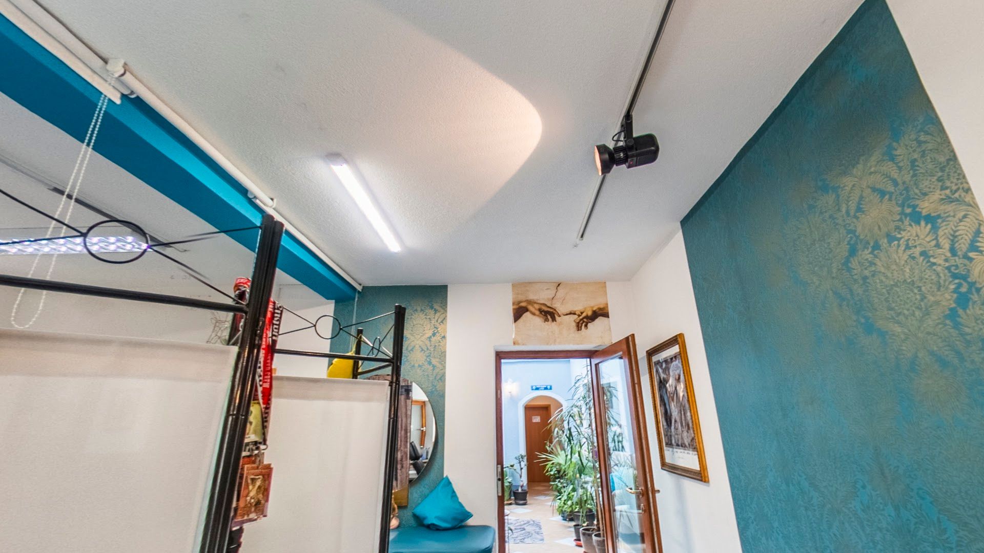 a hallway with a blue wall and a blue chair