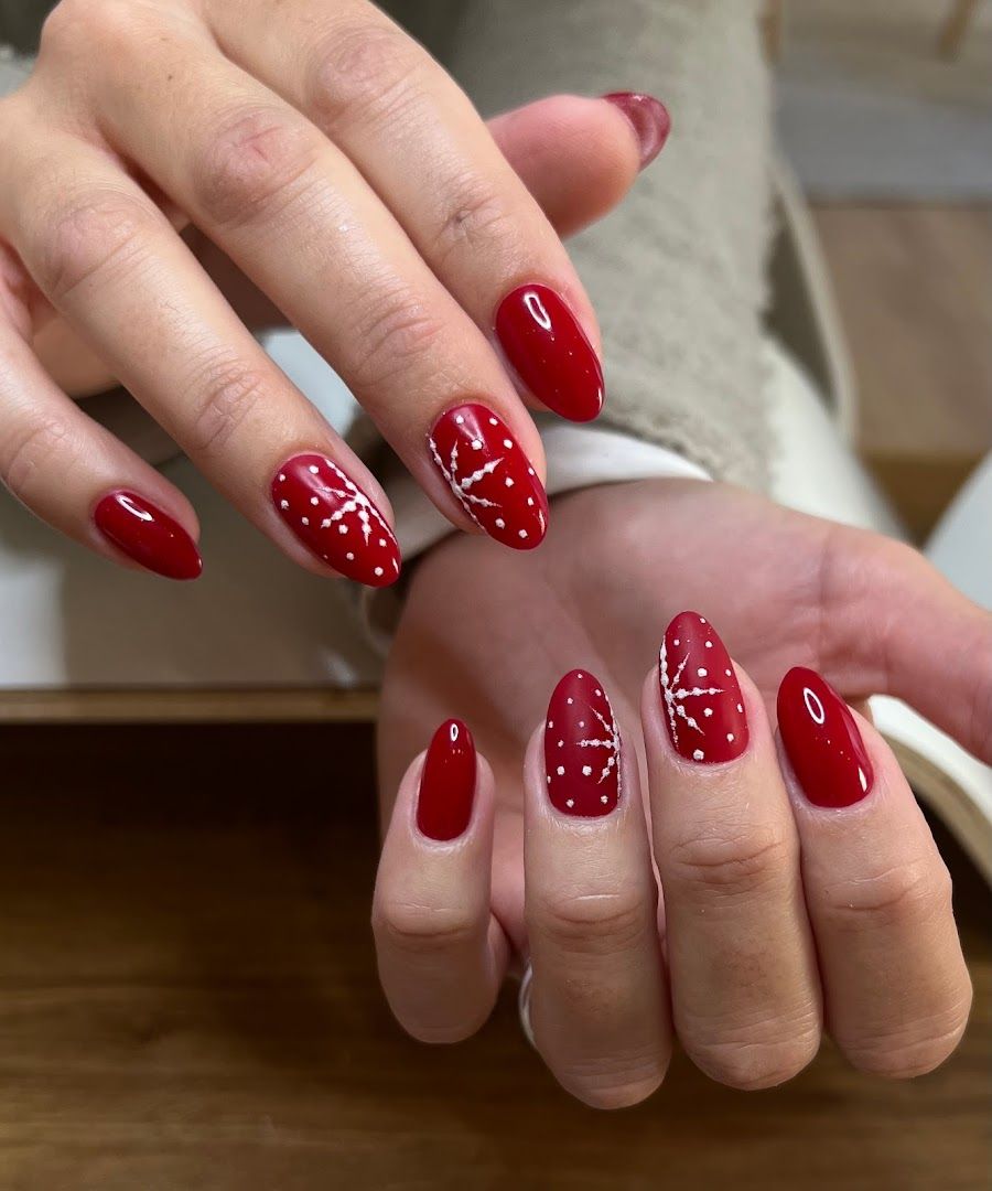 a woman's hand with red and white nail polish