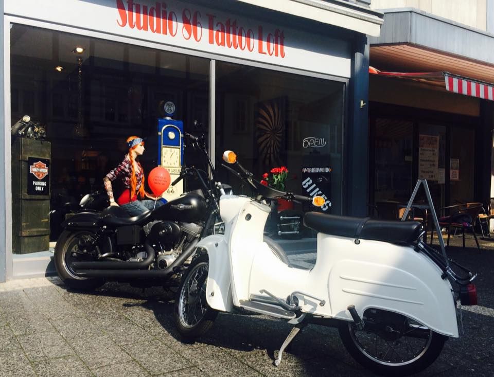 a white motorcycle parked in front of a store