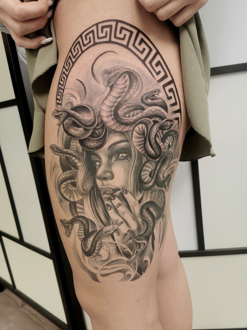 a cover-up tattoo of a woman with a snake on her thigh, mayen-koblenz, germany