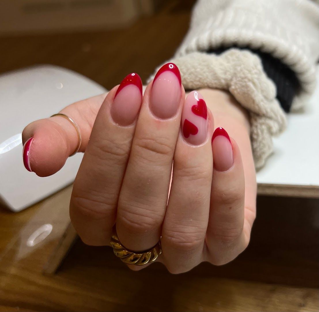 a woman's hand with red nails and a white mani