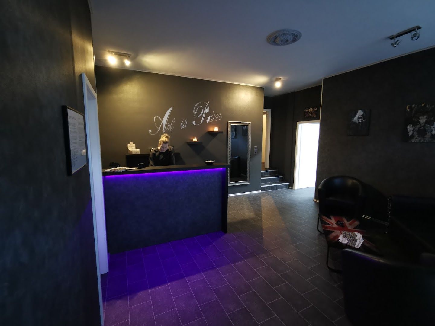 a purple reception area with a black wall and purple lighting