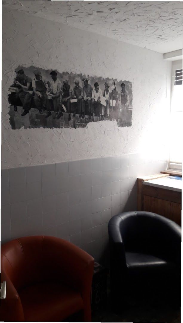 a chair and a wall with a painting on it