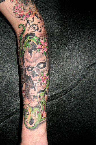 a narben tattoo on the foot of a man with a skull and flowers, oberbergischer, germany