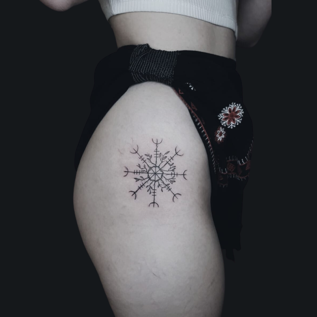 a woman's thigh with a cover-up tattoo of a snowflorer, birkenfeld, germany