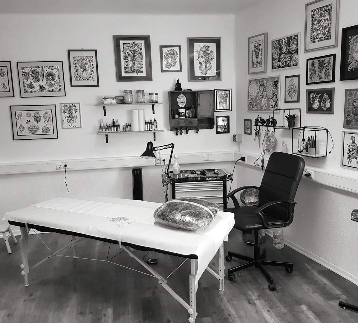 a room with a desk, chair and pictures on the wall