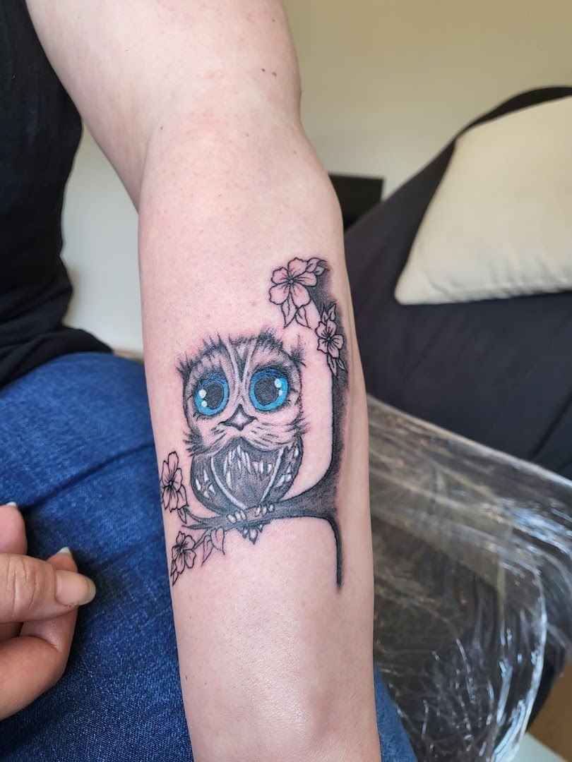 a narben tattoo of an owl with blue eyes and a flower, rotenburg (wümme), germany