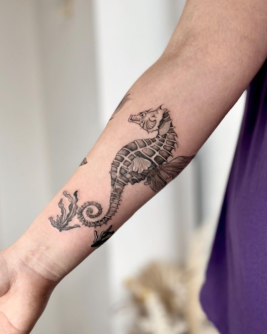 a woman's arm with a narben tattoo of a seahorse, paderborn, germany