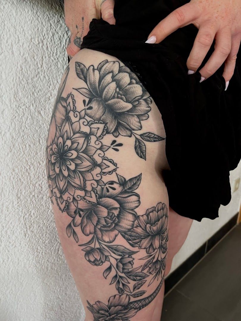 a woman's thigh with a black and white flower cover-up tattoo, kaiserslautern, germany