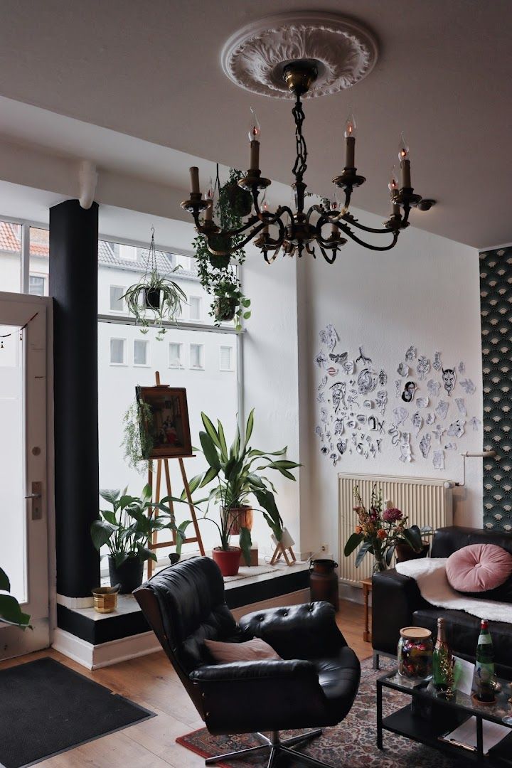 a living room with black leather chairs and a chandel