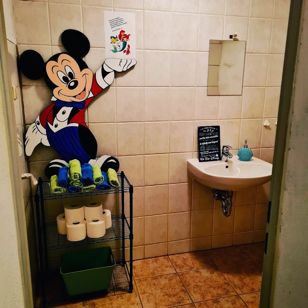 a bathroom with a mickey mouse mural on the wall