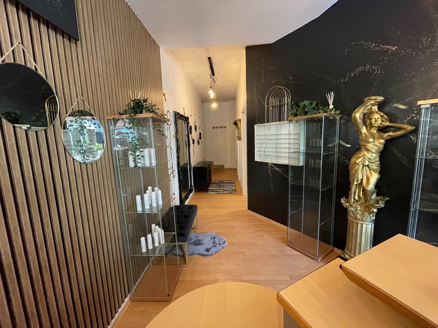 a hallway with a wooden floor and a wall with a gold statue