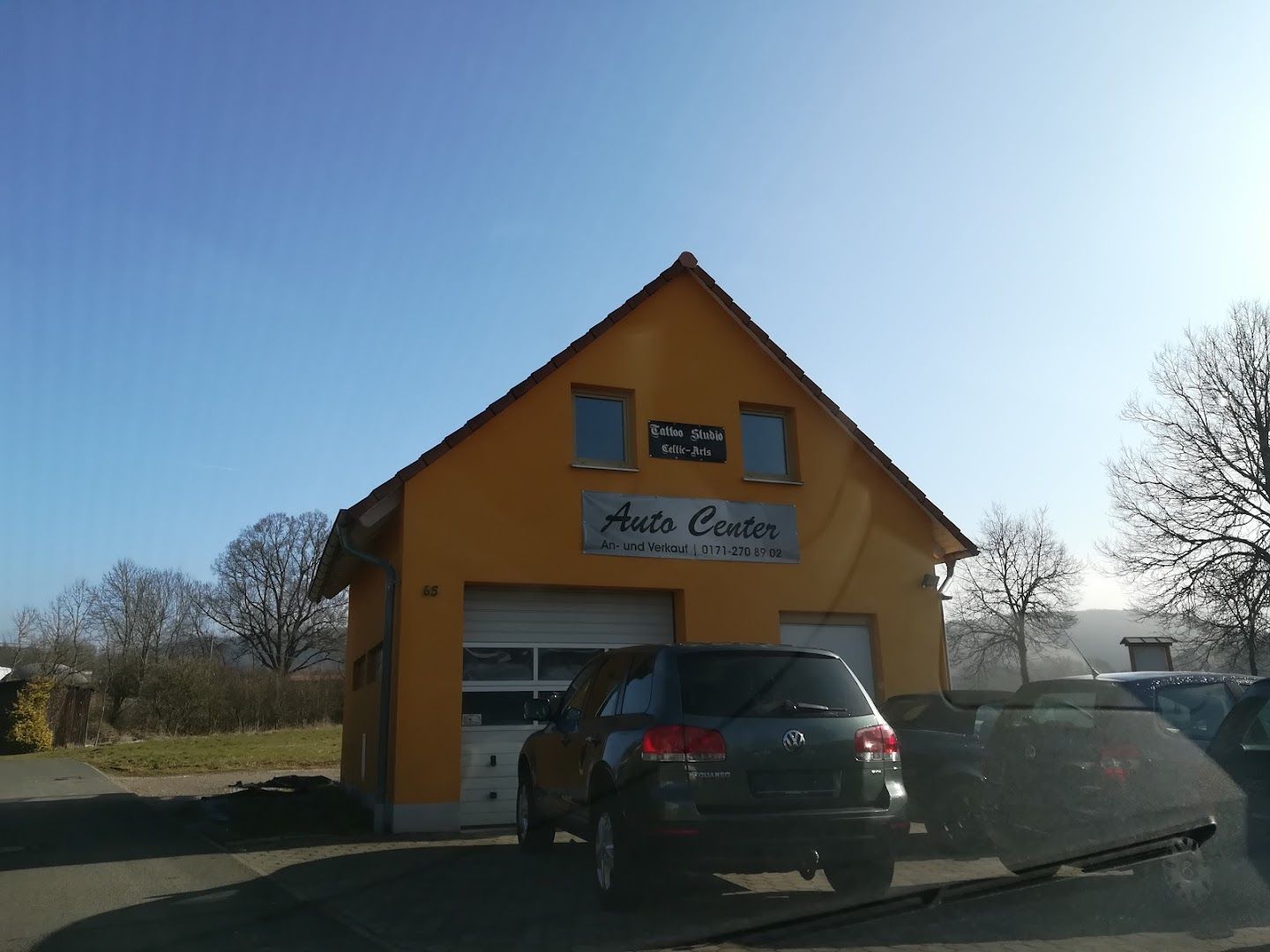 a yellow building with a car parked in front