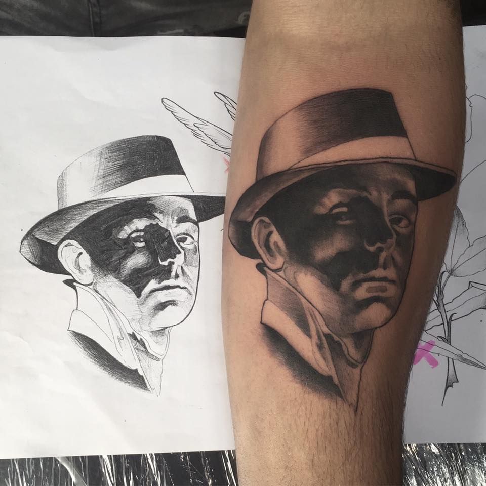 a man with a hat and a hat on his arm