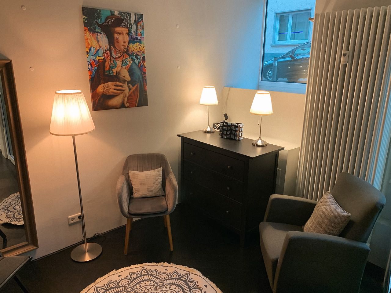 a bedroom with a bed, chair, and a painting