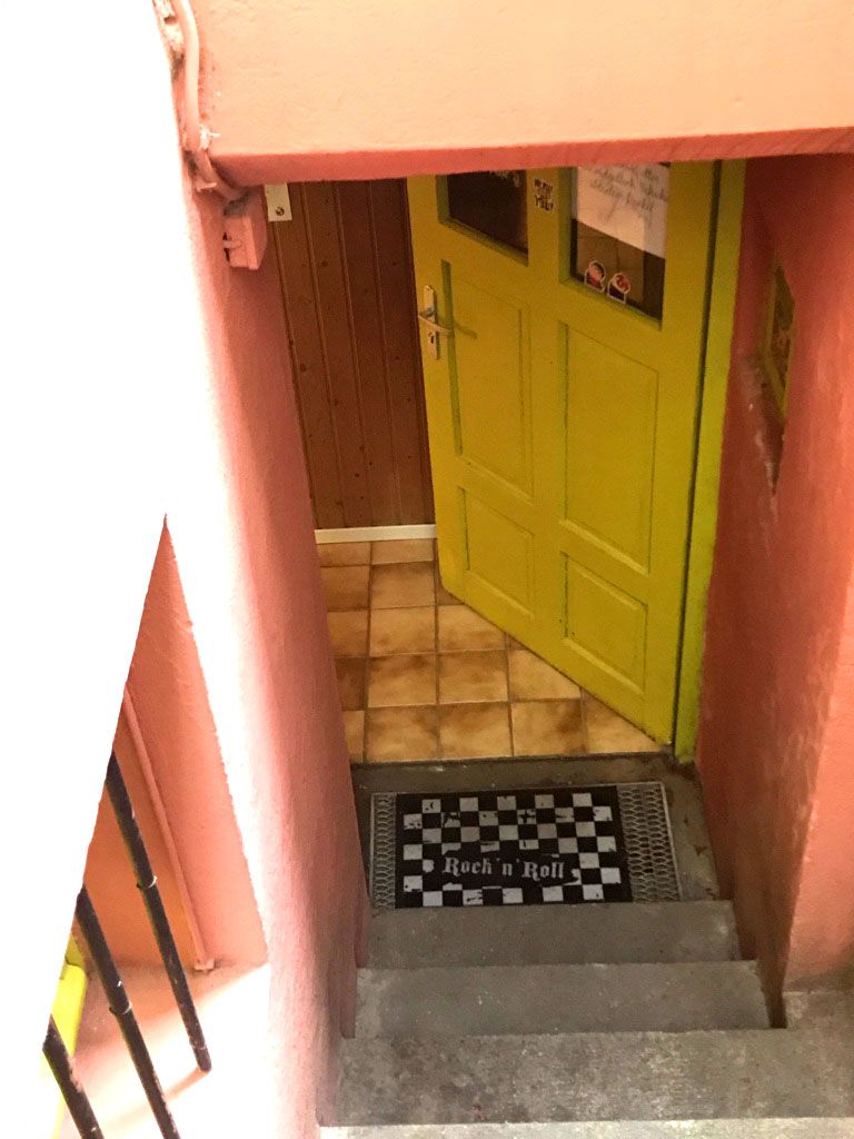 a yellow door is in the corner of a pink building