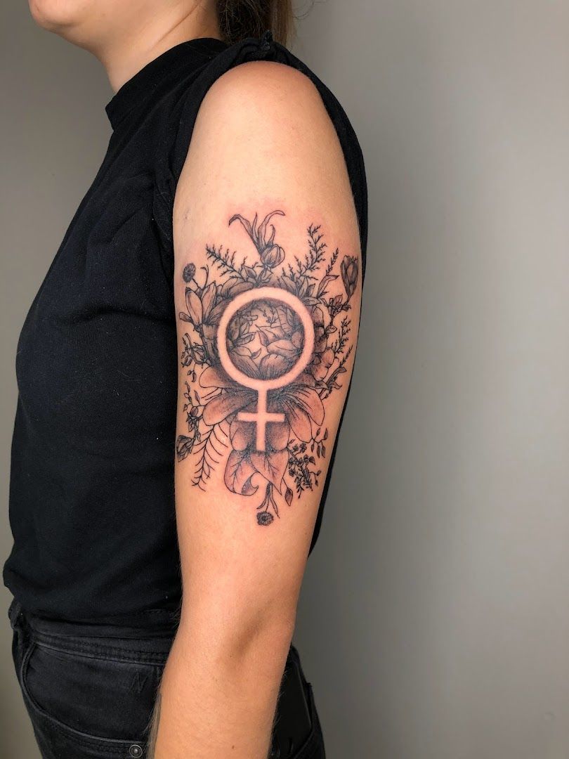 a woman's arm with a narben tattoo of an earth and flowers, stuttgart, germany