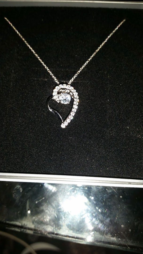 a diamond heart necklace in a box