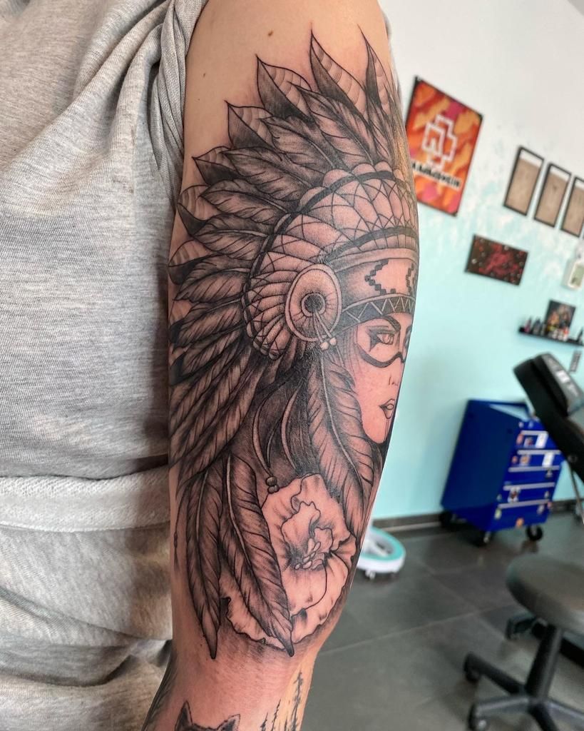 a woman with a feather headdre narben tattoo on her arm, osterholz, germany