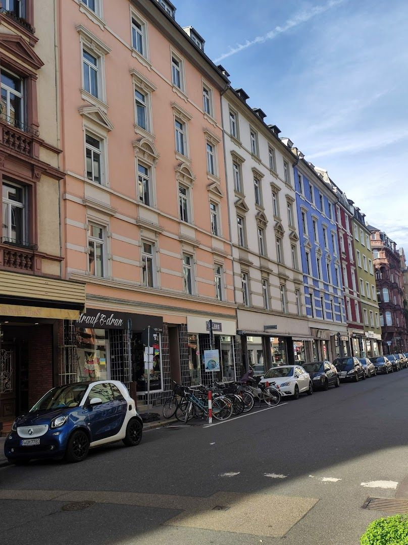 a street with many buildings and parked cars