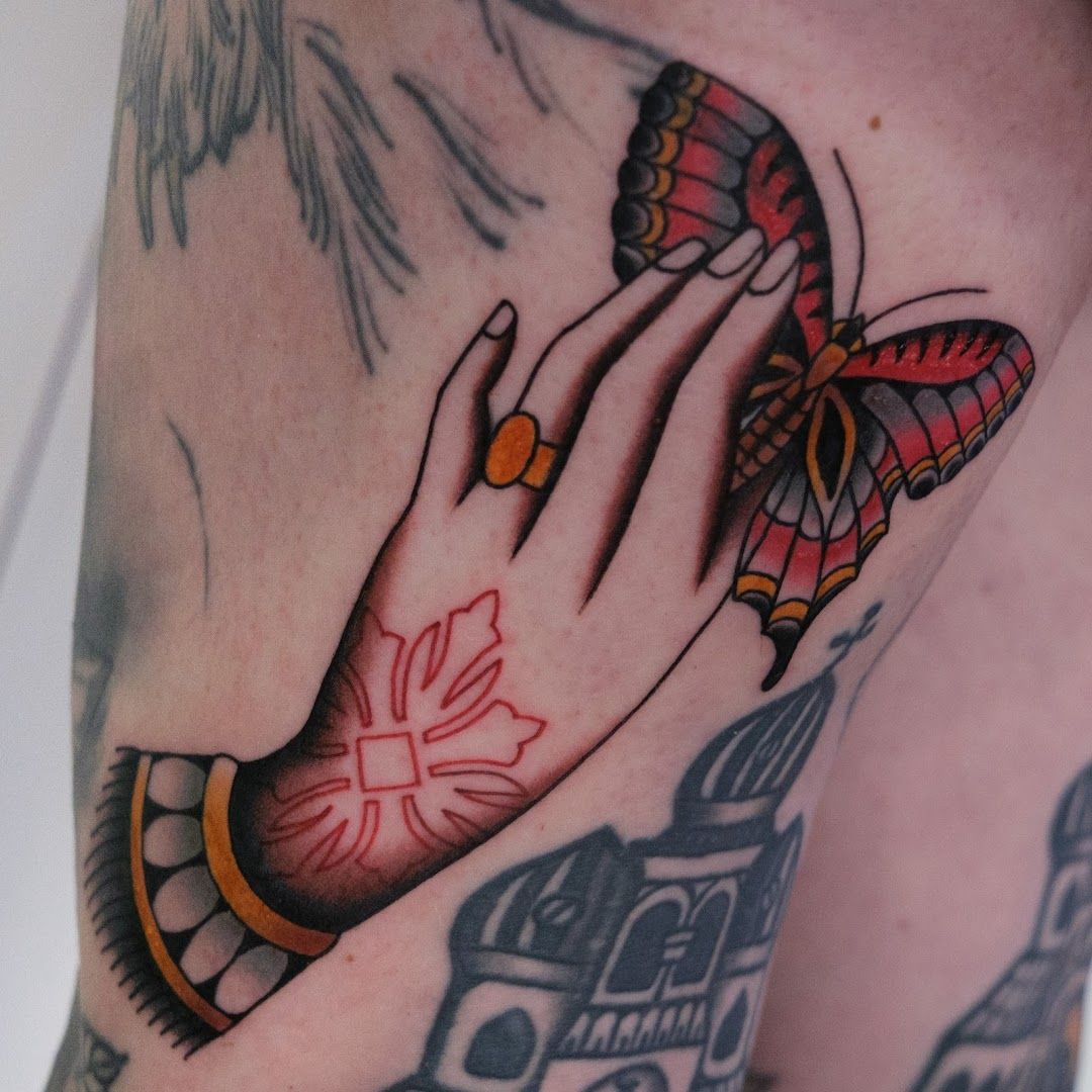 a cover-up tattoo of a hand with a butterfly on it, berlin, germany