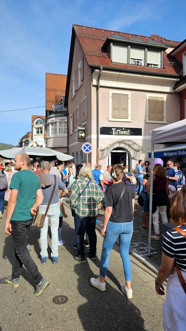 people walking through a street in front of a building
