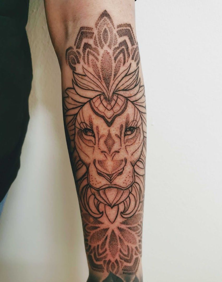 a cover-up tattoo of a lion with a lotus flower on the arm, nordwestmecklenburg, germany