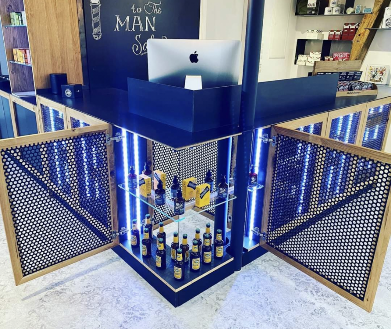 a bar with a laptop and bottles of alcohol