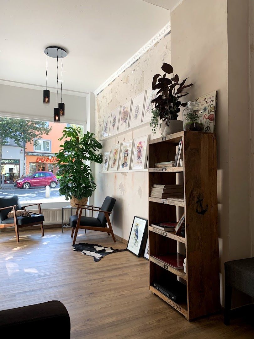 a living room with a couch, bookshel and a plant