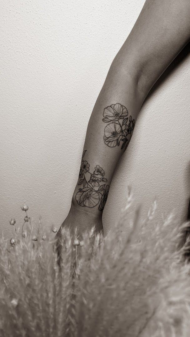 a woman's arm with a narben tattoo of flowers, vulkaneifel, germany
