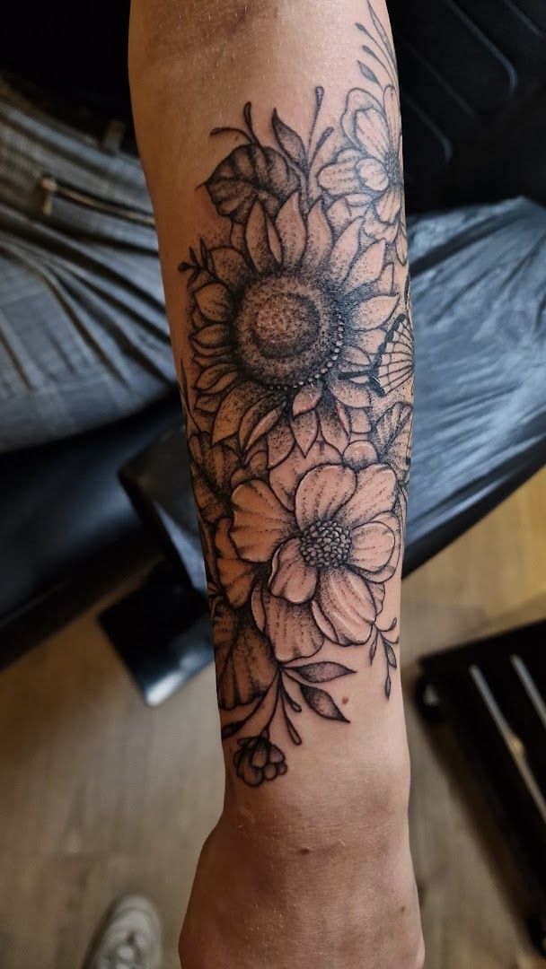 a black and white narben tattoo with flowers on the arm, enzkreis, germany