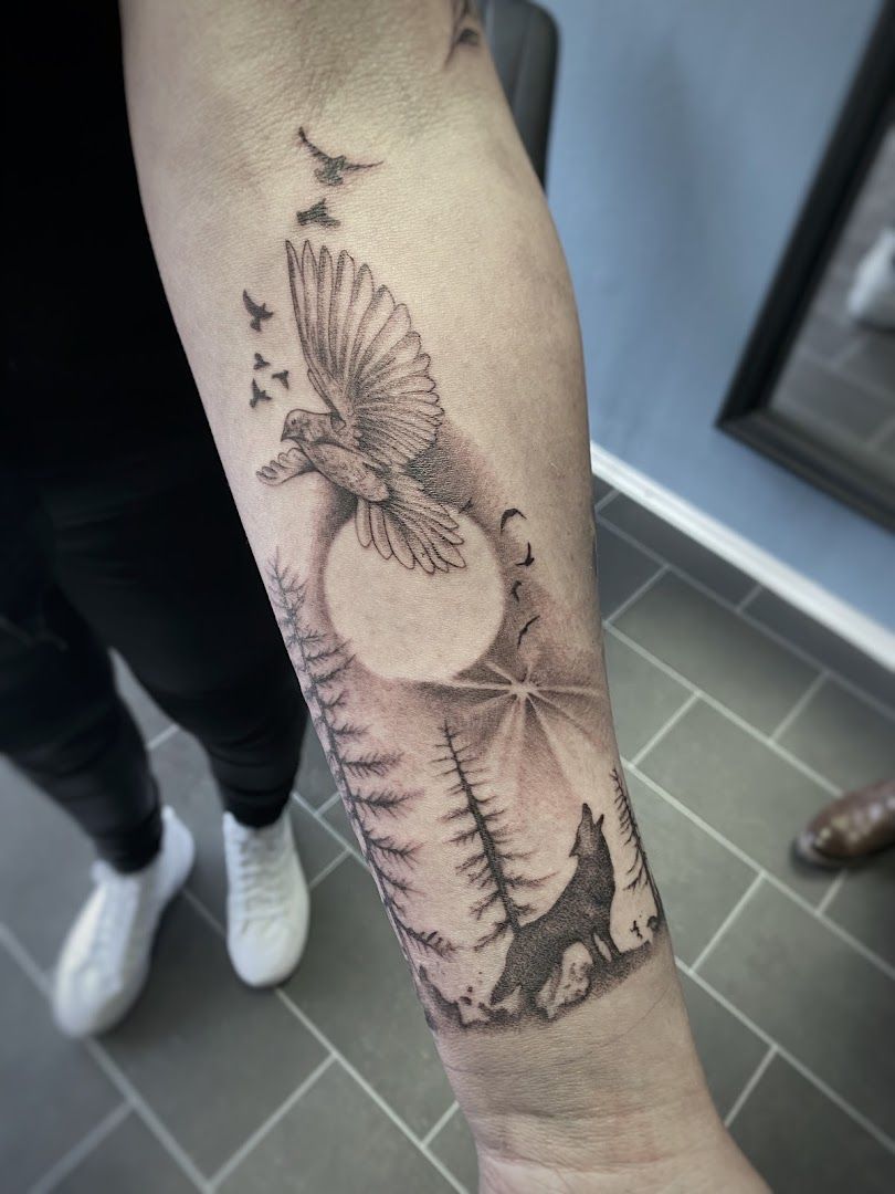 a bird flying over a forest with a mountain scene cover-up tattoo on the forearm, rhein-erft district, germany