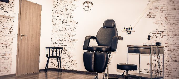 a salon room with a chair and a mirror