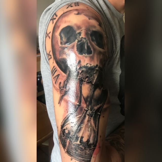 a man with a skull and cross cover-up tattoo on his arm, sigmaringen, germany