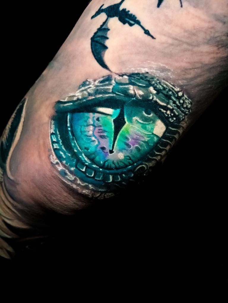 a cover-up tattoo with a dragon eye and a dragon on the inside, berlin, germany