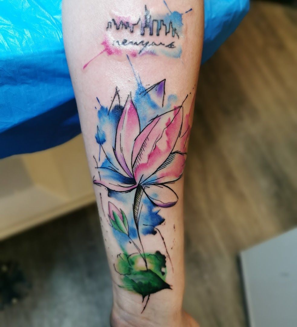 a watercolor narben tattoo with a lotus flower on the forearm, soest, germany